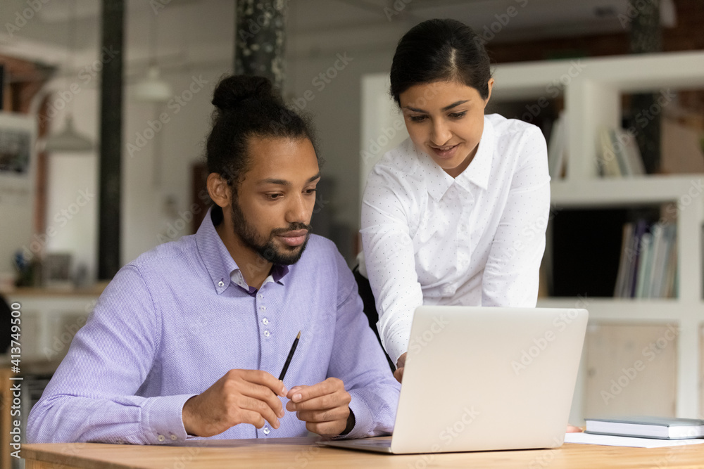 Canvas Prints Focused multiethnic colleagues coworkers look at laptop screen discuss business ideas together. Diverse multiracial businesspeople work together cooperate brainstorm using computer in office.