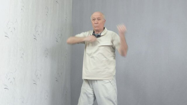 Old man in sportswear performing elbow strikes
