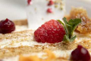 Cake with cream and strawberries on a dark wood background. A piece of cake close-up on a plate.