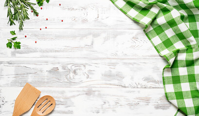White wooden table covered with green tablecloth and cooking utensils. View from top. Empty tablecloth for product montage. Free space for your text - 413752993