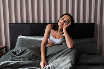 Obraz premium Attractive young woman waking up in bed in the morning