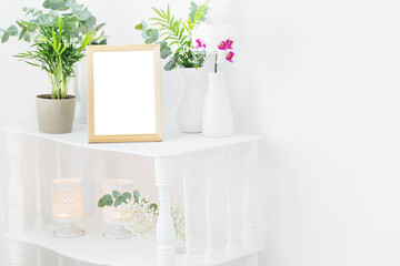 wooden frame on vintage white shelf with flowers and plants