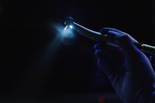 Dentist hand with drill illustrates the operation of the dentist dental drill machine with water