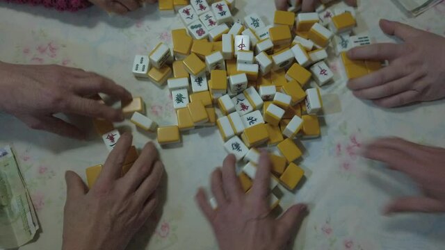 Playing mahjong - asian gaming activity at home to celebrate Chinese New Year