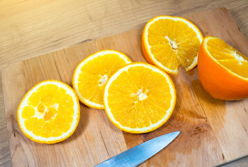 Obraz na płótnie Canvas Many slices of orange lie on wooden kitchen board. Fresh citrus fruit..