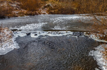 Fototapeta na wymiar Fast river with ice in late autumn