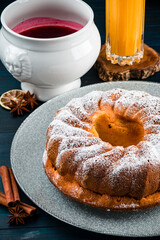 Bundt cake with sugar powder with copy space. Homemade ring cake with icing sugar on wooden table, closeup, rustic style.