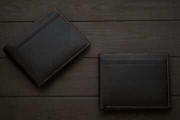 Fashionable black leather men's wallet on top of wooden table