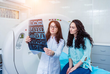 Radiologist with a female patient examining a CT scan
