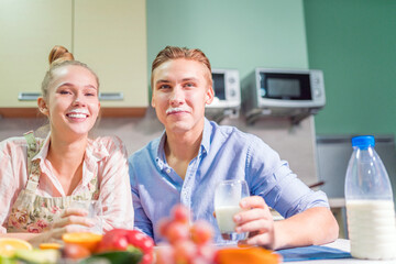 Husband and wife drink milk from glasses. Young family