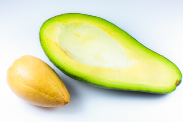 Close up photo of avocado on white background. Healthy fruit cut in half with seeds inside, macro view.