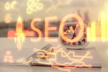 Multi exposure of SEO drawings and desk with open notebook background. Concept of Search optimization