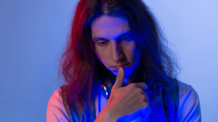 Obraz premium Student or programmer at a laptop, portrait in neon tinting. Funny guy geek writes code.