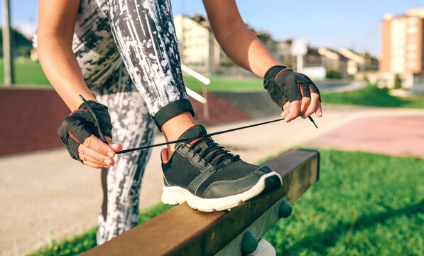 Low section of woman tying shoelaces at park