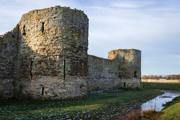 View of Pevensey Castle ruins in East Sussex south east England with South Downs in the background
