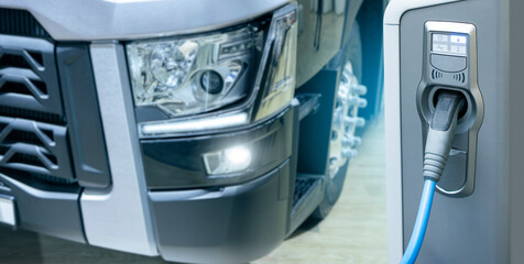 Electric vehicles charging station on a background of a truck. Concept © scharfsinn86