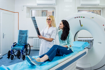 Radiologist with a female patient examining a CT scan