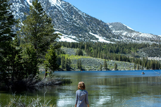 Rear view of girl standing by lake against clear sky at Inyo National Forest