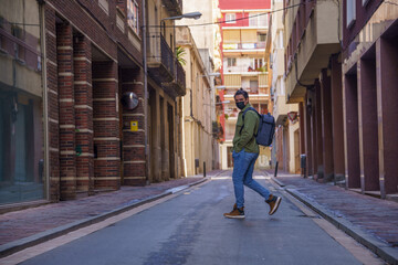 Obraz premium Man crossing the street with backpack on his back