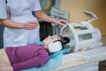 Radiologist prepares the little girl for an MRI brain examination