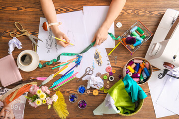 Female fashion designer working with sketches in studio, closeup