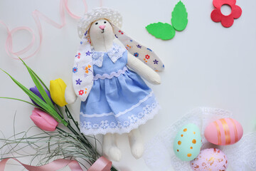 easter greeting card for kids. flowers, willow twigs, easter bunny figurine, easter eggs and space for text 