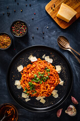 Spaghetti bolognese with minced pork meat and parmesan on black table