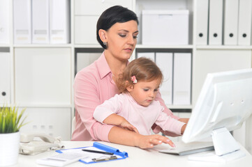 Portrait of  businesswoman with her child  working in office