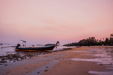 Obraz premium small fishing boat on the beach in the evening
