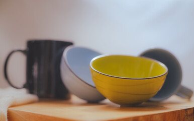 Abstract background blue and yellow on wood and beautiful light from window.Empty black cup bowl on  ceramic bowl ceramic texture.