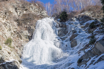 A waterfall frozen in winter in the mountains.