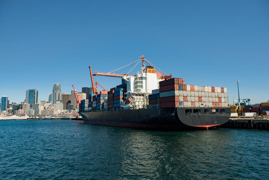 Container ship moored at commercial dock against clear blue sky