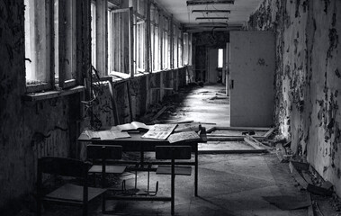 interior of an old abandoned school building with broken windows and lost books 
