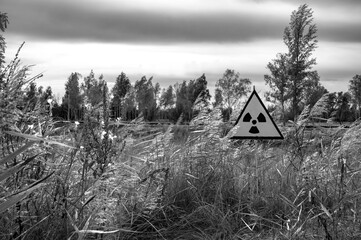 catastrophic landscape of shinning field with nuclear danger sign with dramatic sky 