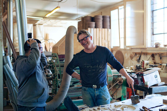 Happy male carpenters talking in workshop
