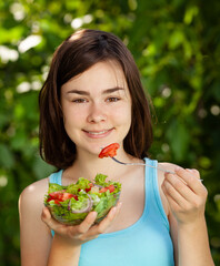 Girl eating fresh vegetable salad
