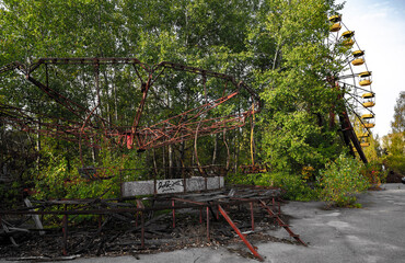 rusty amusement park rides defeated by forest in abandoned town due to nuclear catastrophe  