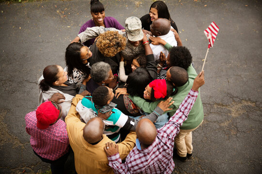 Family hugging soldier while standing on road