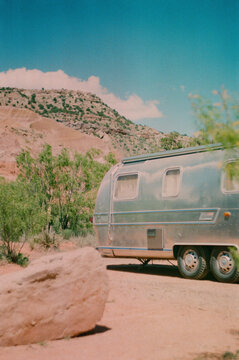 Vertical Shot Of A Retro Vintage RV Parked In A Dense Forest During A Holiday Trip