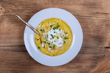 Kulesha - Hutsul corn porridge, cooked on water, served with cheese, butter, cheese and sour cream on the plate, Western Ukraine