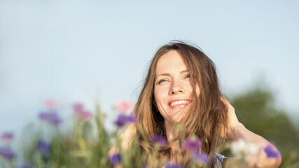 Beautiful woman with long hair over sky and flower background