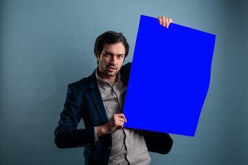 Happy smiling man showing blank signboard with empty copyspace area for slogan or advertising text...
