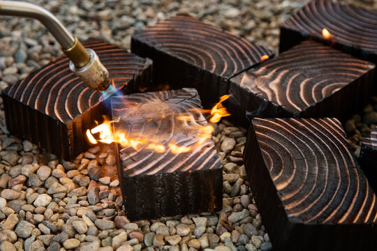 Close-up of welding torch burning wood on stones