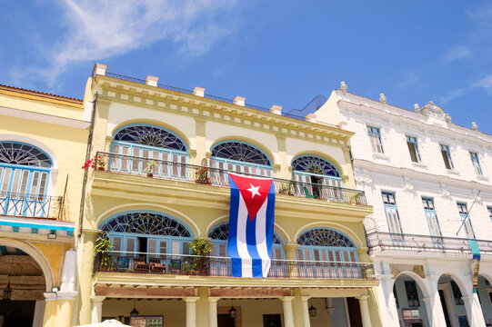 Cuban flag hanging on building against blue sky