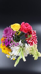 Close up. Beautiful bouquet of blooming colorful bright flowers isolated in dark background. 