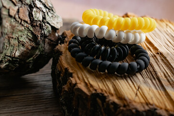 Fashionable and modern elastic hair springs. Different colors of stretching hand bracelets on wooden background, stand