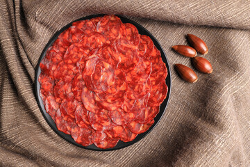 Portion of 100% acorn-fed Iberian chorizo from Extremadura decorated with acorns