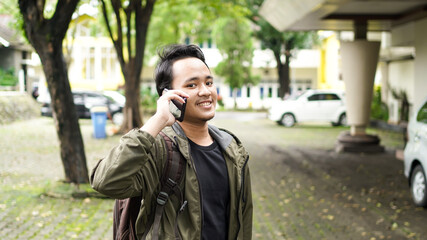 Asian man wearing a bag while telephone