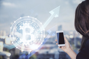 Double exposure of blockchain business sketch hologram and woman holding and using a mobile device.