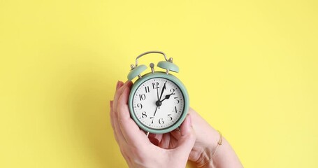 Woman forwarding the clock one hour ahead for daylight saving time